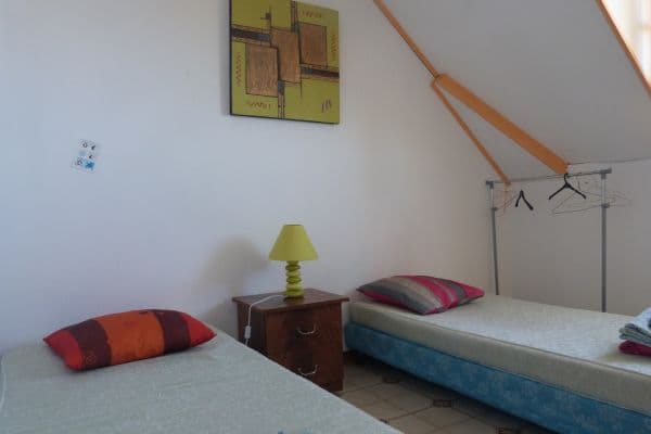 Les lits jumeaux de la chambre Vanille à l'auberge de jeunesse de Saint-Leu