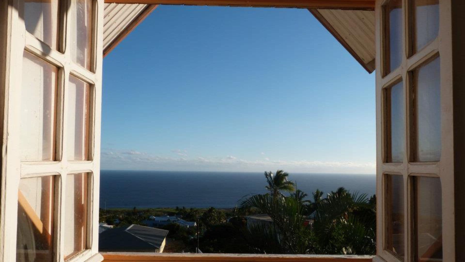 Vue sur l'océan Indien depuis une fenêtre de la case créole de l'auberge de jeunesse Éliz'O Z'Îles à Piton Saint-Leu