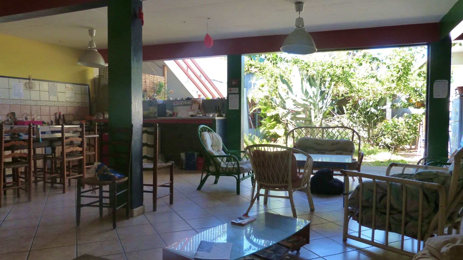 Le salon commun ouvert sur le jardin tropical de l'auberge de jeunesse à Saint-Leu